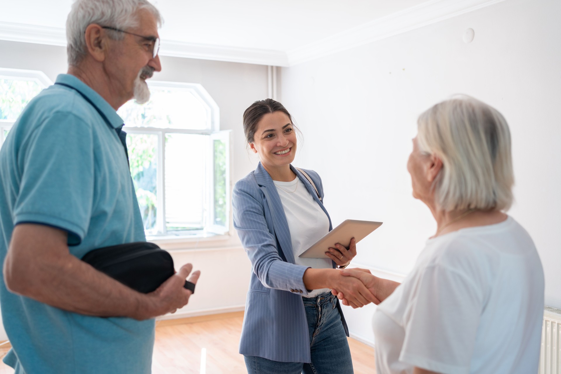 Senior Couple Handshake With Real Estate Agent At Home